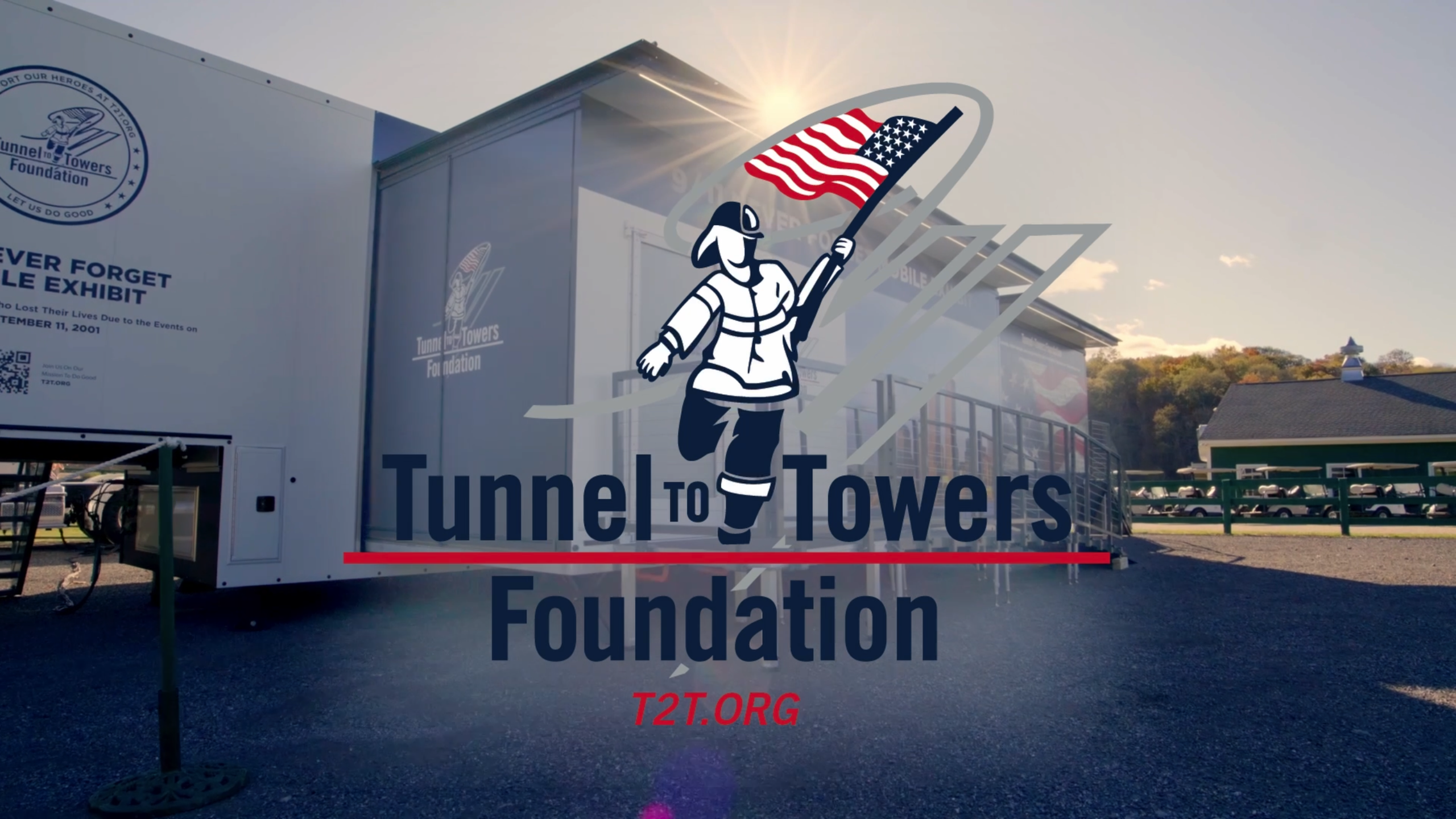 Mobile exhibit trailer for the Tunnel to Towers Foundation with the organizations logo and website, T2T.ORG, displayed in the foreground.