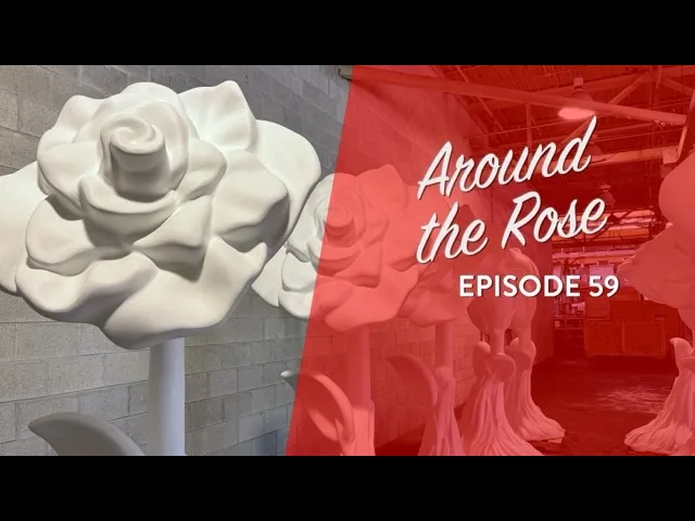 Large white rose sculptures stand in an industrial space; text overlay reads Around the Rose Episode 59 on a red background.