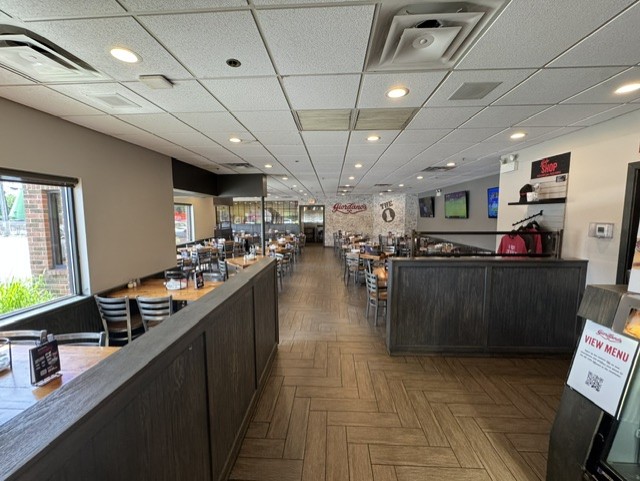 Interior view of a Giordanos restaurant with tables, chairs, and wood-paneled partitions.