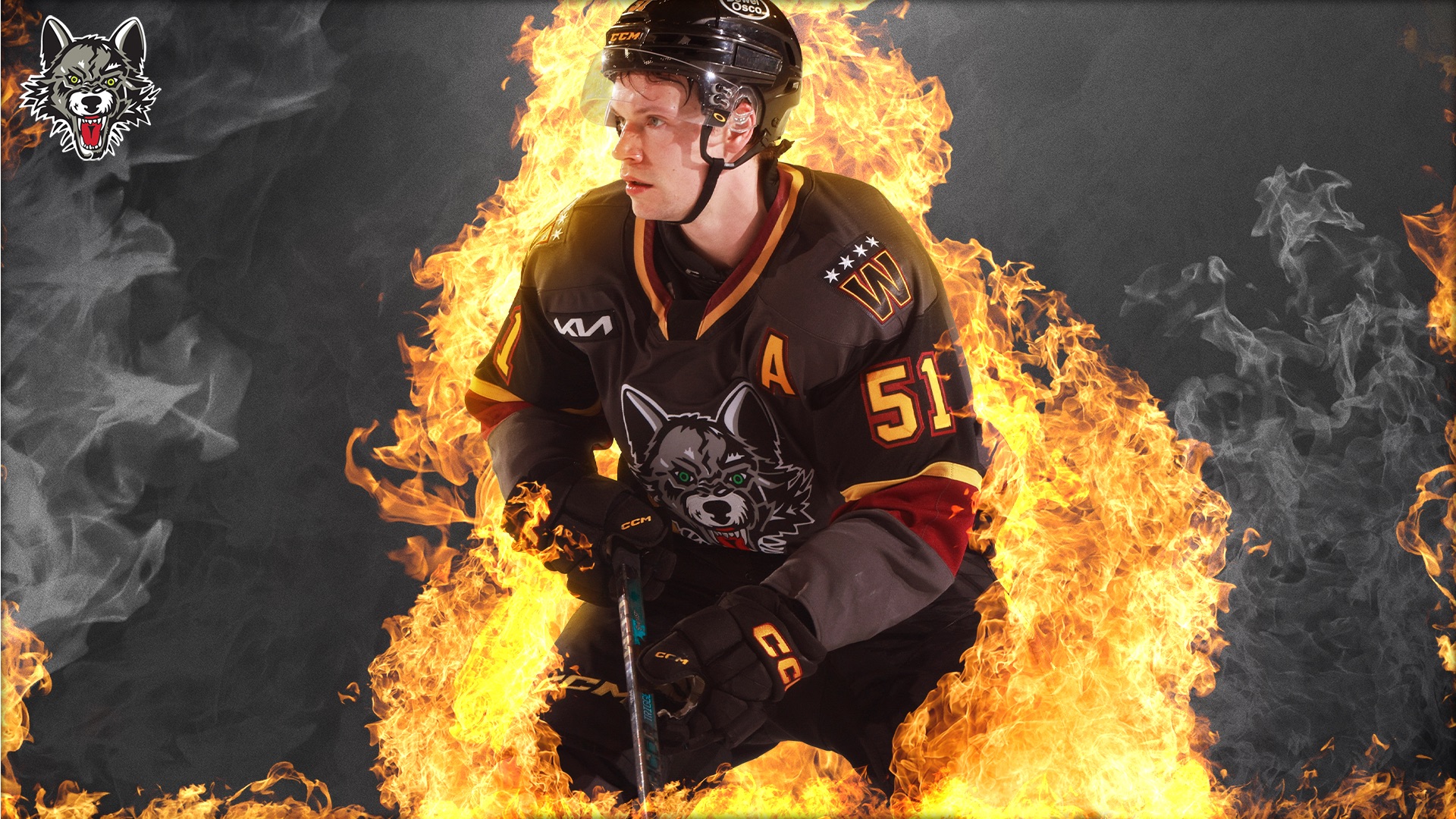 A hockey player in a dark uniform with a wolf logo is surrounded by fiery flames. He is holding a hockey stick and wearing a helmet, with an intense expression. The teams wolf logo is also in the top left corner.