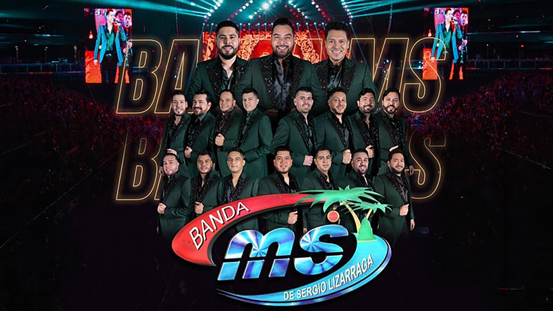 A group photo of Banda MS members in dark suits with the bands logo in front of them and a concert crowd in the background.